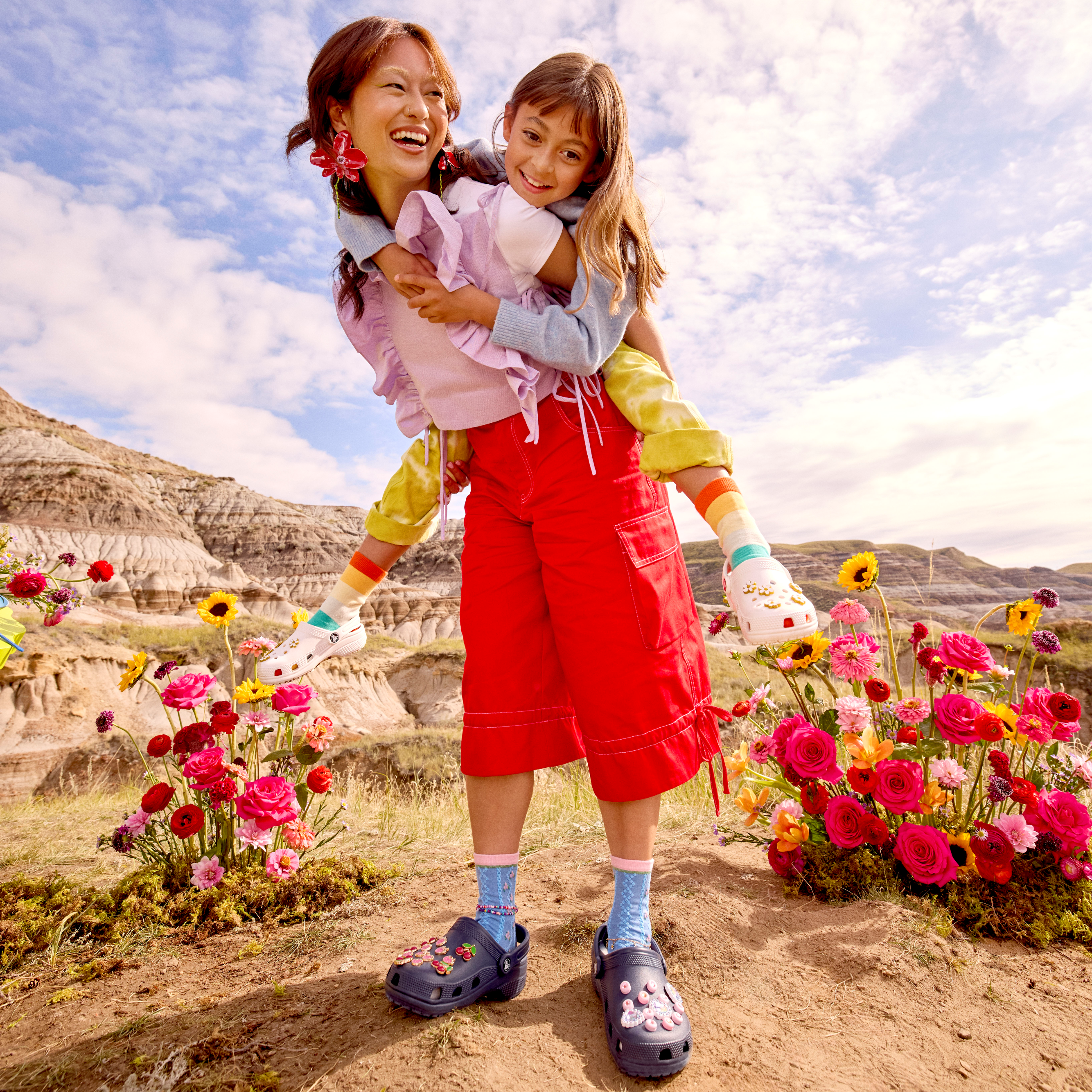 Woman wearing 10001 Crocs Classic Unisex Clogs Navy 410 giving a young girl a piggy back ride