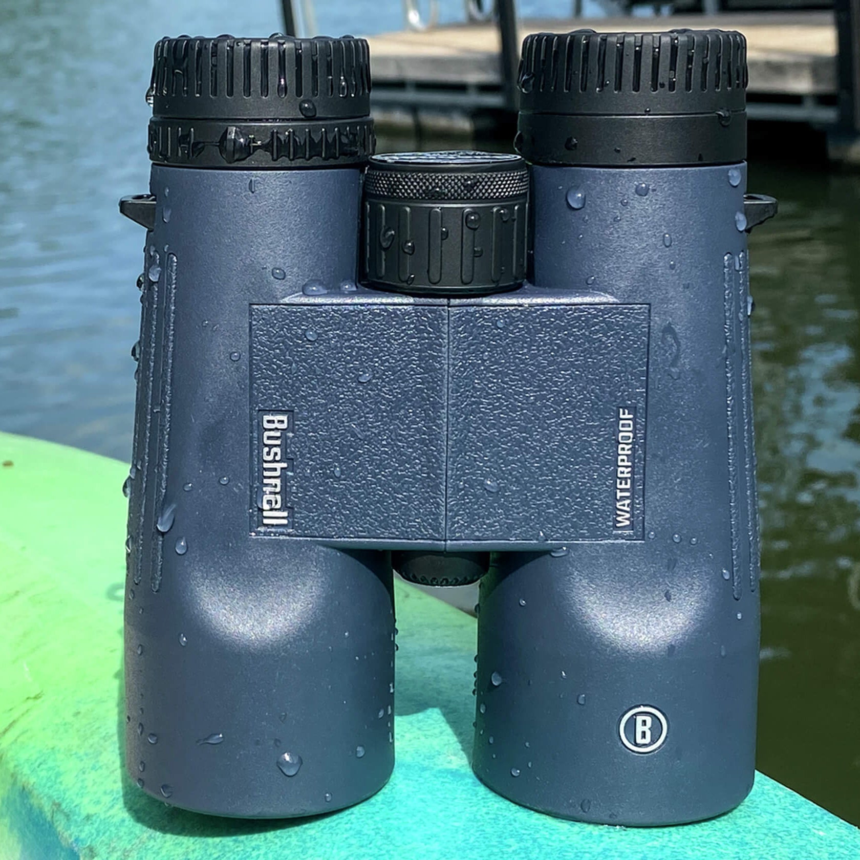 Bushnell H2O Aluminium 10x42 Roof Binoculars BH150142R sitting on a kayak with water drops on it by water