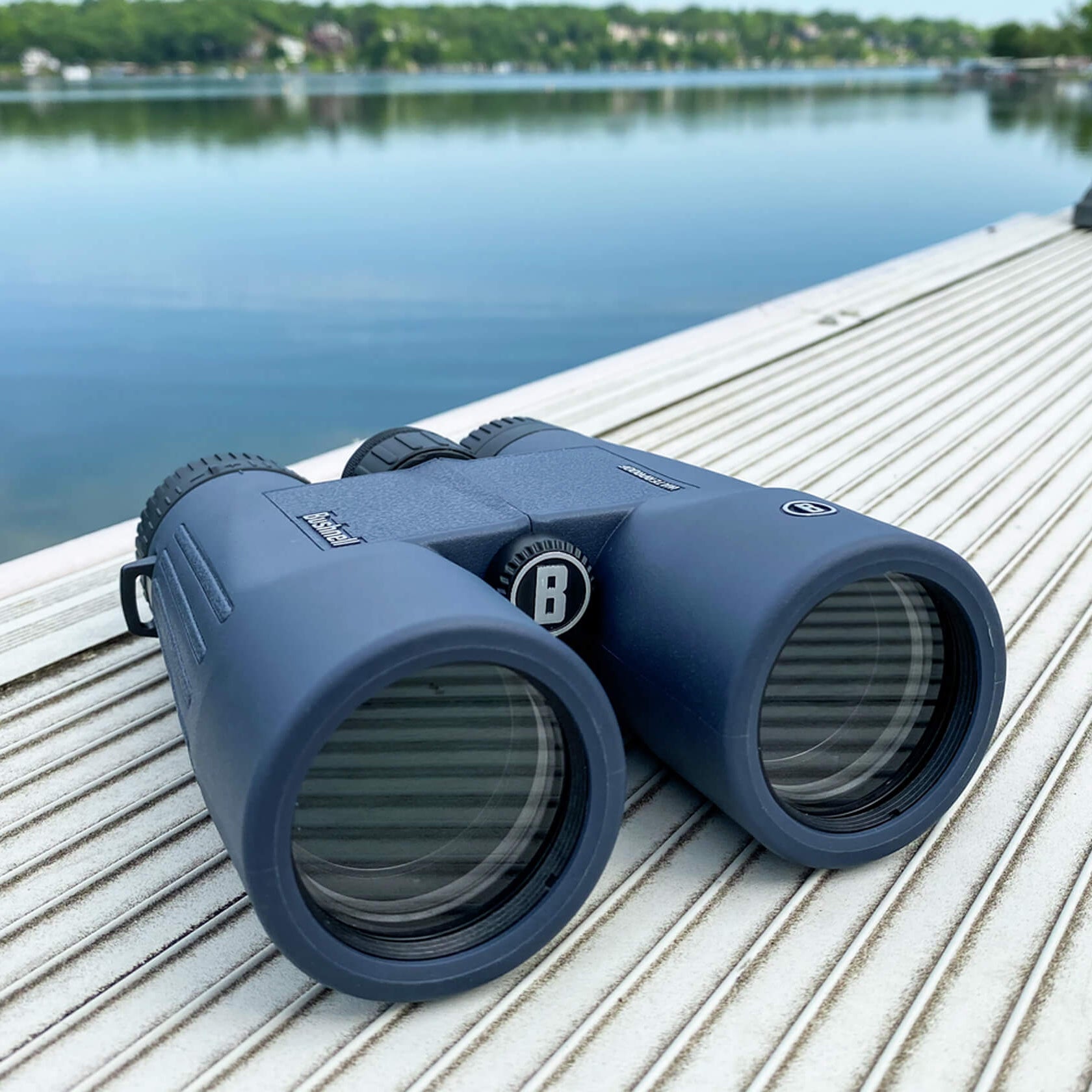 Bushnell H2O Aluminium Roof Binoculars sitting on a wooden dock by a lake
