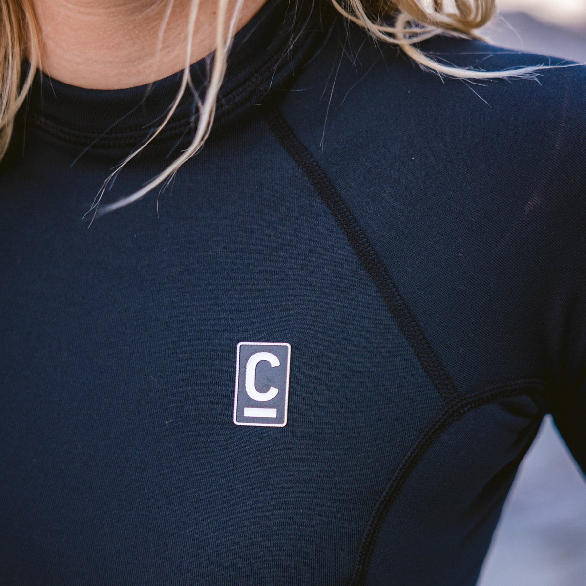 Close up of a woman wearing the C-Skins Women's HDi Thermal Long Sleeve Rash Vest Black C-HDILSWC