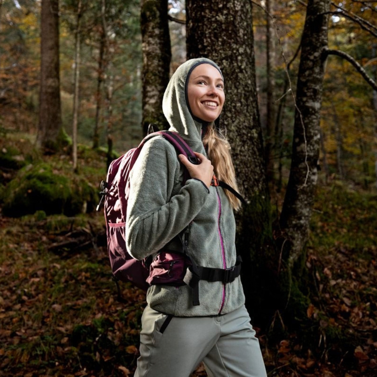 Woman standing in a forest, wearing a hoody and a CMP Laredo Trekking Daypack 22L C910 Amaranto 3V17957