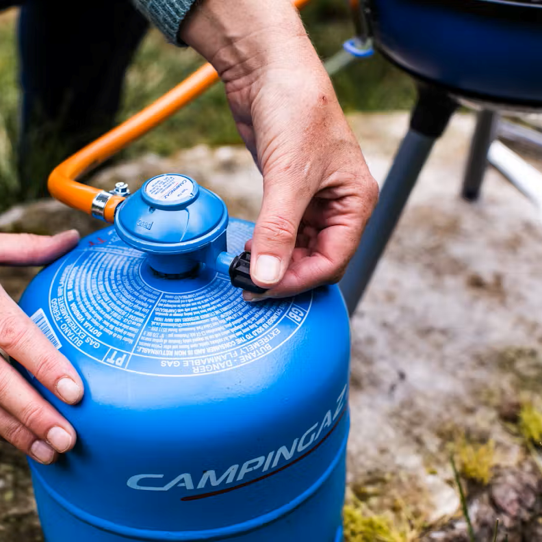 Man connecting a Camping Gaz 907 Gas Refill Only GAS907 to a camping stove