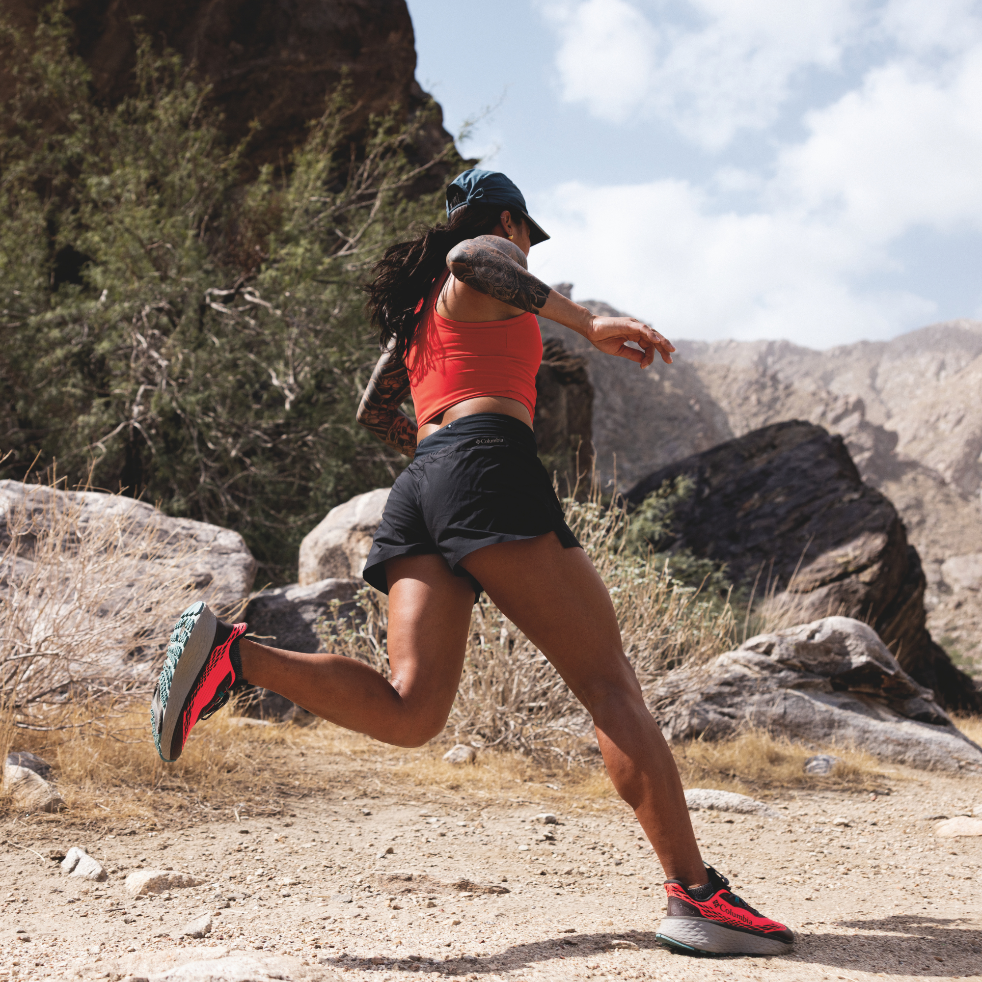Woman trail running in Columbia Women's Konos Trillium ATR Trail Shoes Neon Sunrise Teal Chloride 648 2145291 on desert gravel surface
