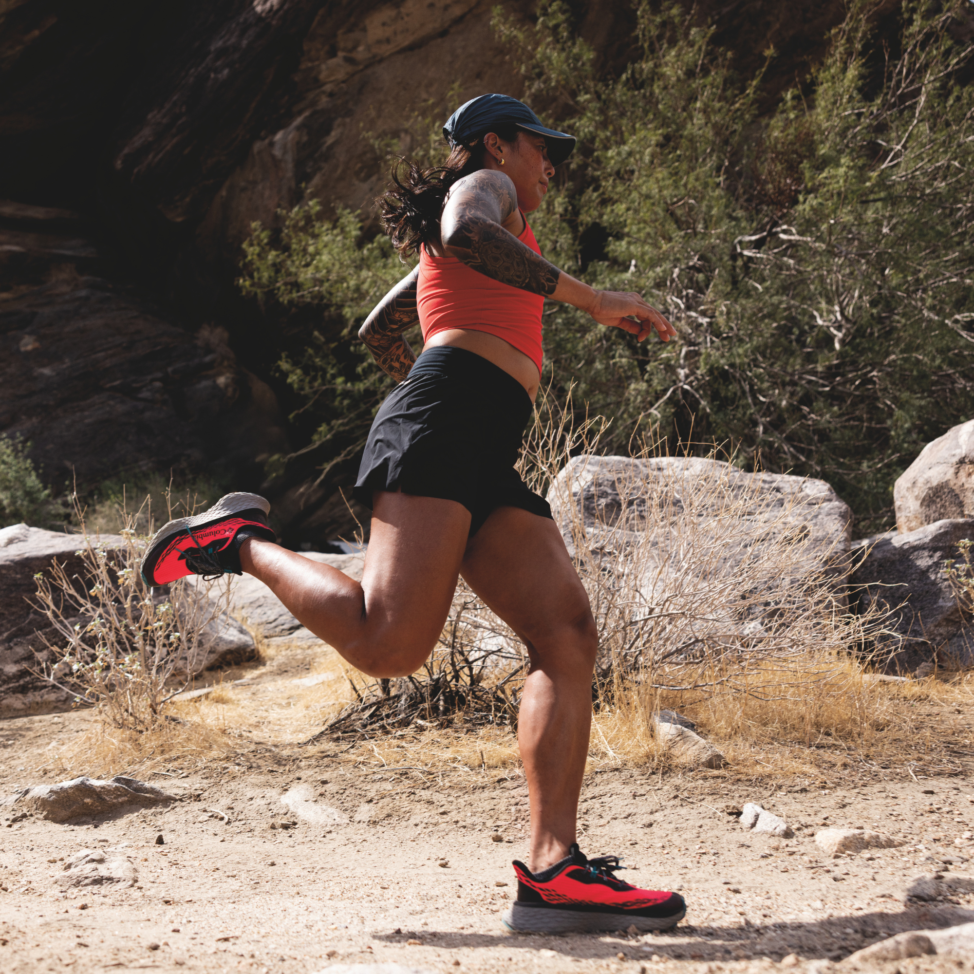 Woman trail running in Columbia Women's Konos Trillium ATR Trail Shoes Neon Sunrise Teal Chloride 648 2145291 on desert gravel surface