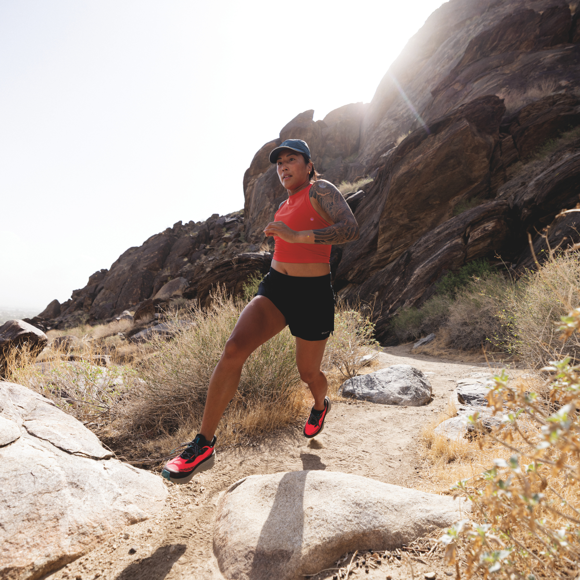 Woman trail running in Columbia Women's Konos Trillium ATR Trail Shoes Neon Sunrise Teal Chloride 648 2145291 on desert gravel surface