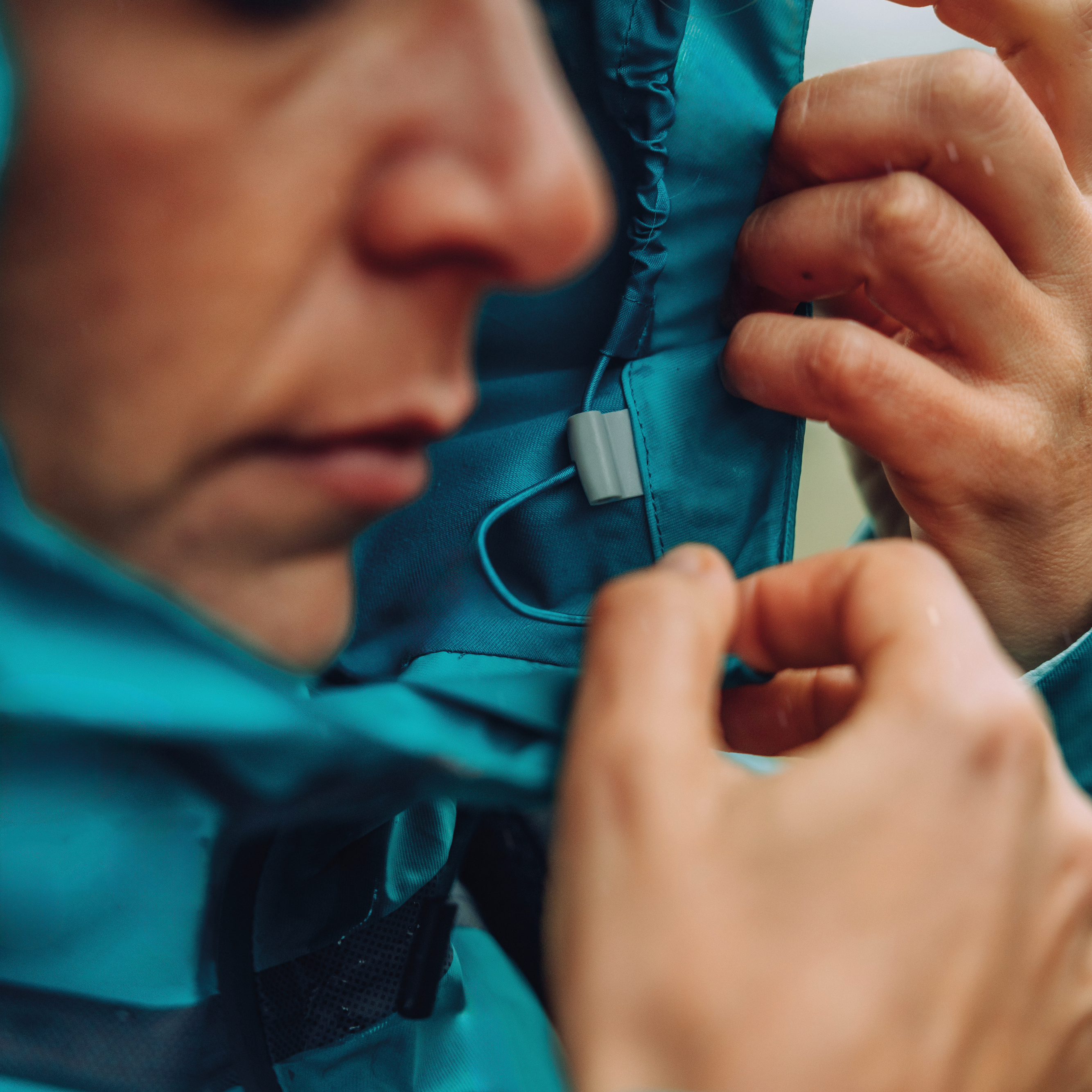 Woman adjusting a Columbia Women's Reign No Shine Outdry Extreme Waterproof Jacket River Blue 364 2116293 with a blurred background