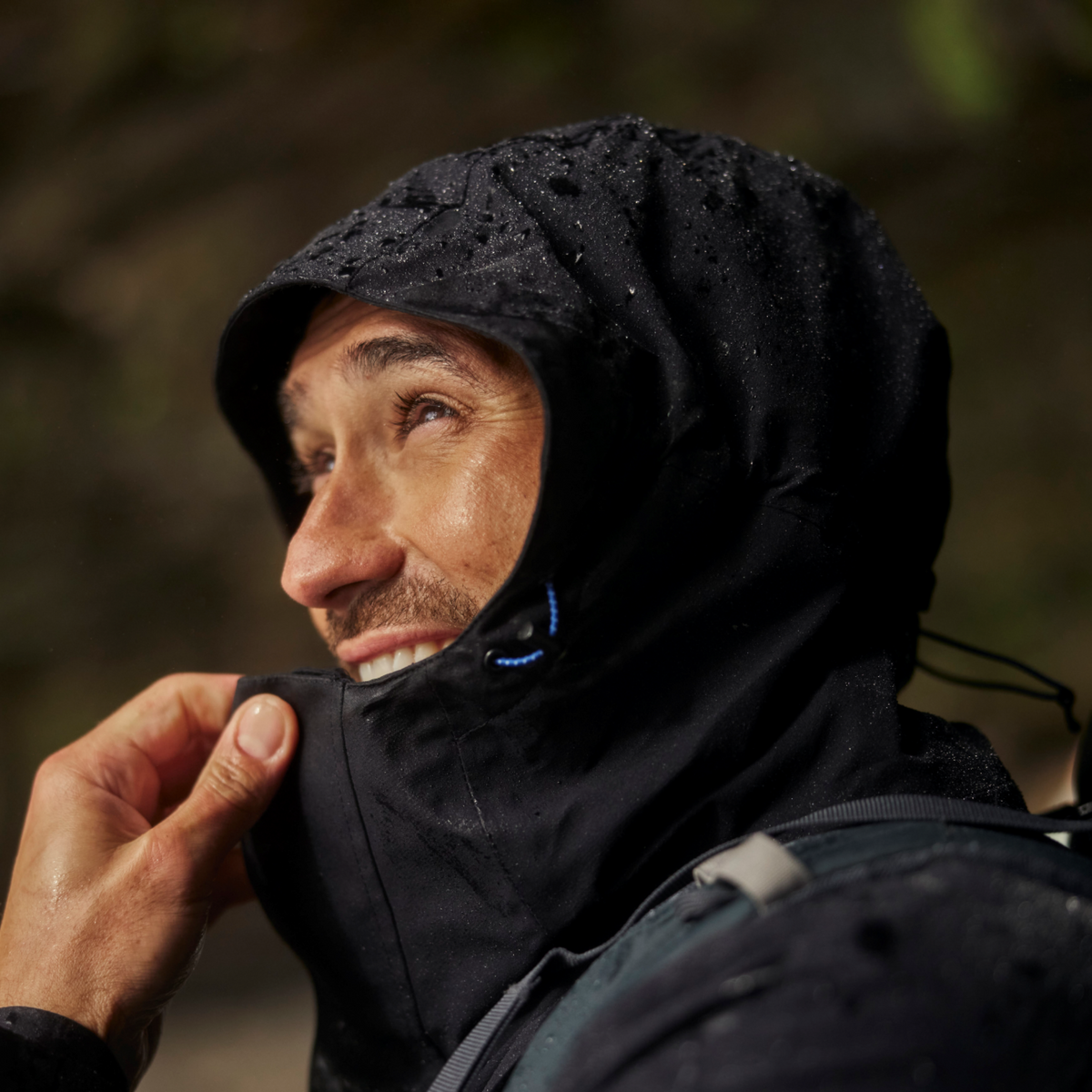 Person wearing a Craghoppers Men's Lorton II Waterproof Jacket Dark Navy 3G3 CMW831 with a hood in a natural setting