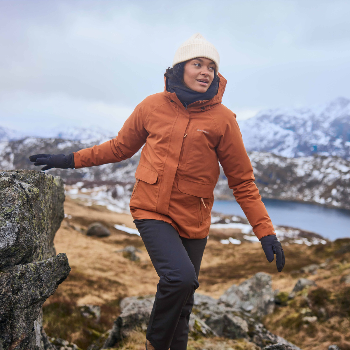 Woman wearing Craghoppers Women's Aysgarth Pro Thermo Waterproof Trousers Black 800 CWW1228 hiking in a winter setting
