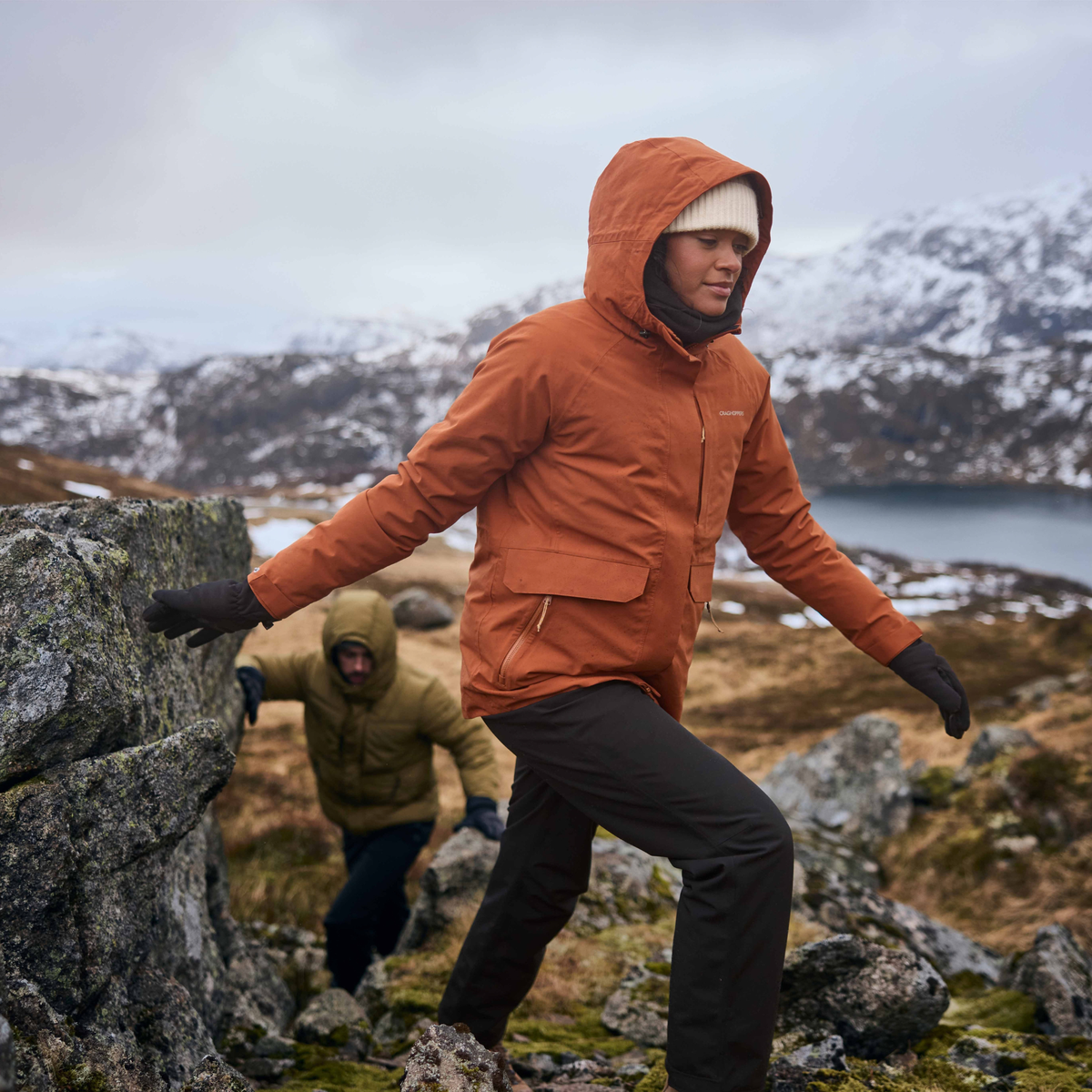 Woman wearing Craghoppers Women's Aysgarth Pro Thermo Waterproof Trousers Black 800 CWW1228 hiking up a winter mountain
