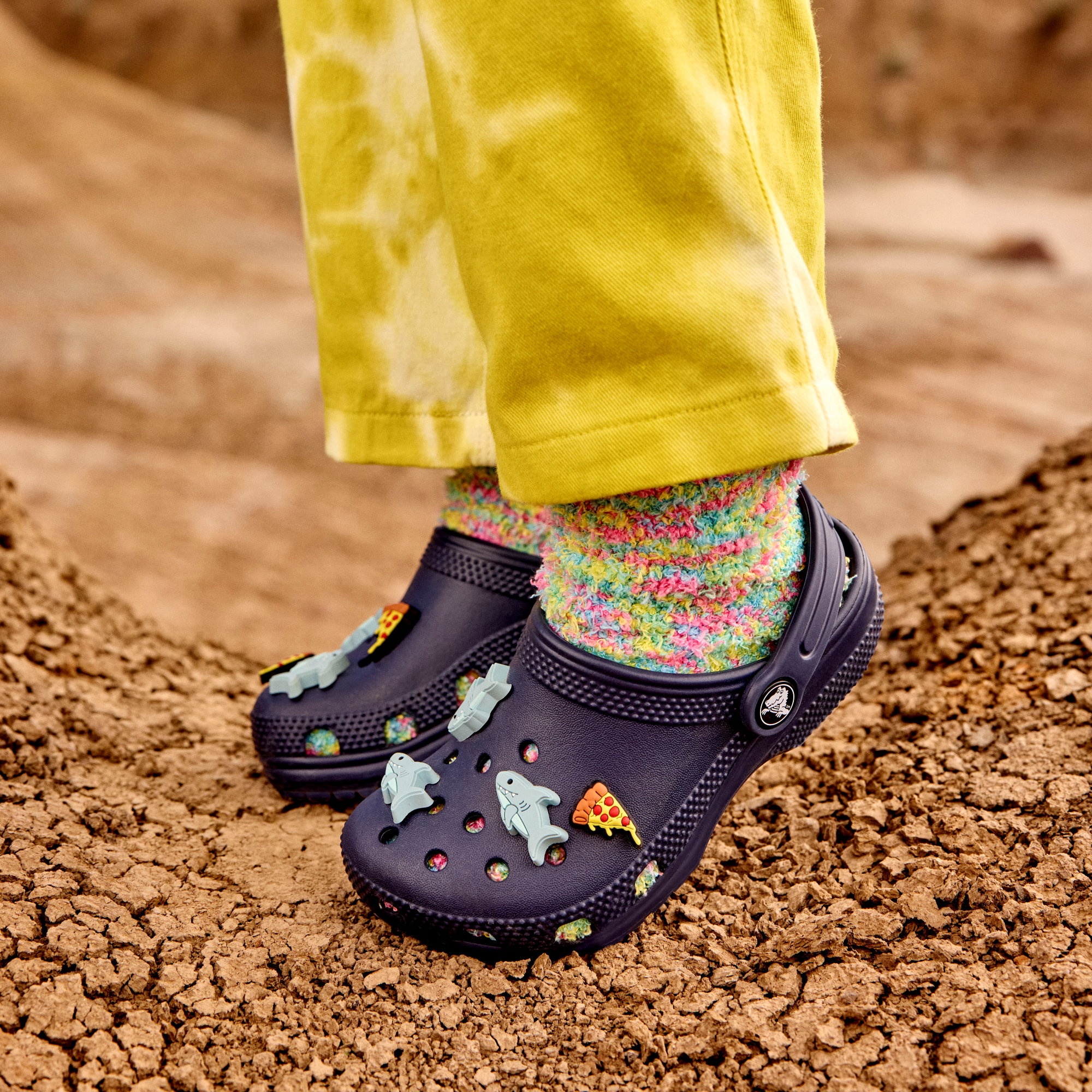 Young girl wearing Crocs Classic Clogs Junior Navy 410 206991 in a desert setting