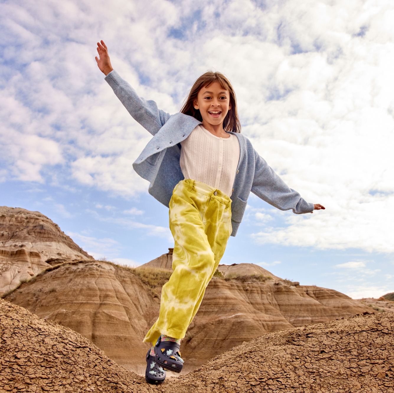 Young girl wearing Crocs Classic Clogs Junior Navy 410 206991 in a desert setting