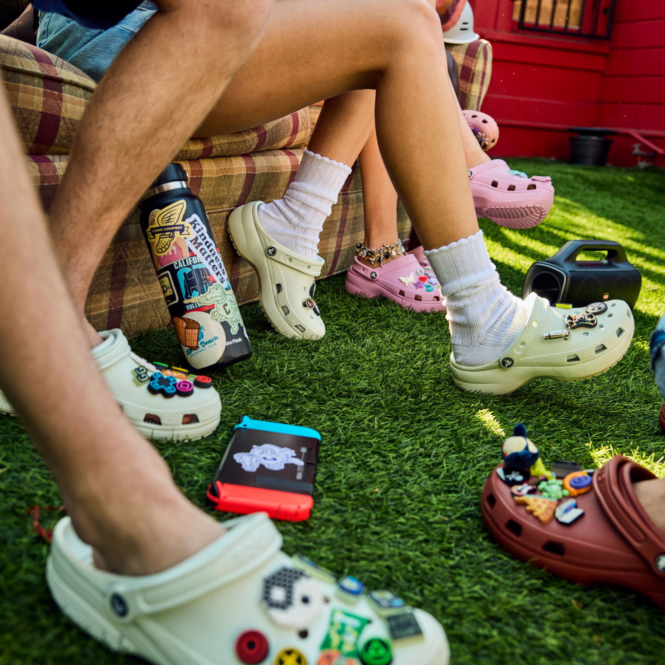 People wearing Crocs Unisex Classic Clogs Mint Tint 3YF 10001 sitting on a couch on grass