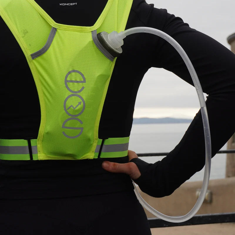 Person wearing a reflective safety vest with a blurred background and Eos Elite 700ml Water Bladder with Drinking Tube Black EOS-WB-700 inside back poket