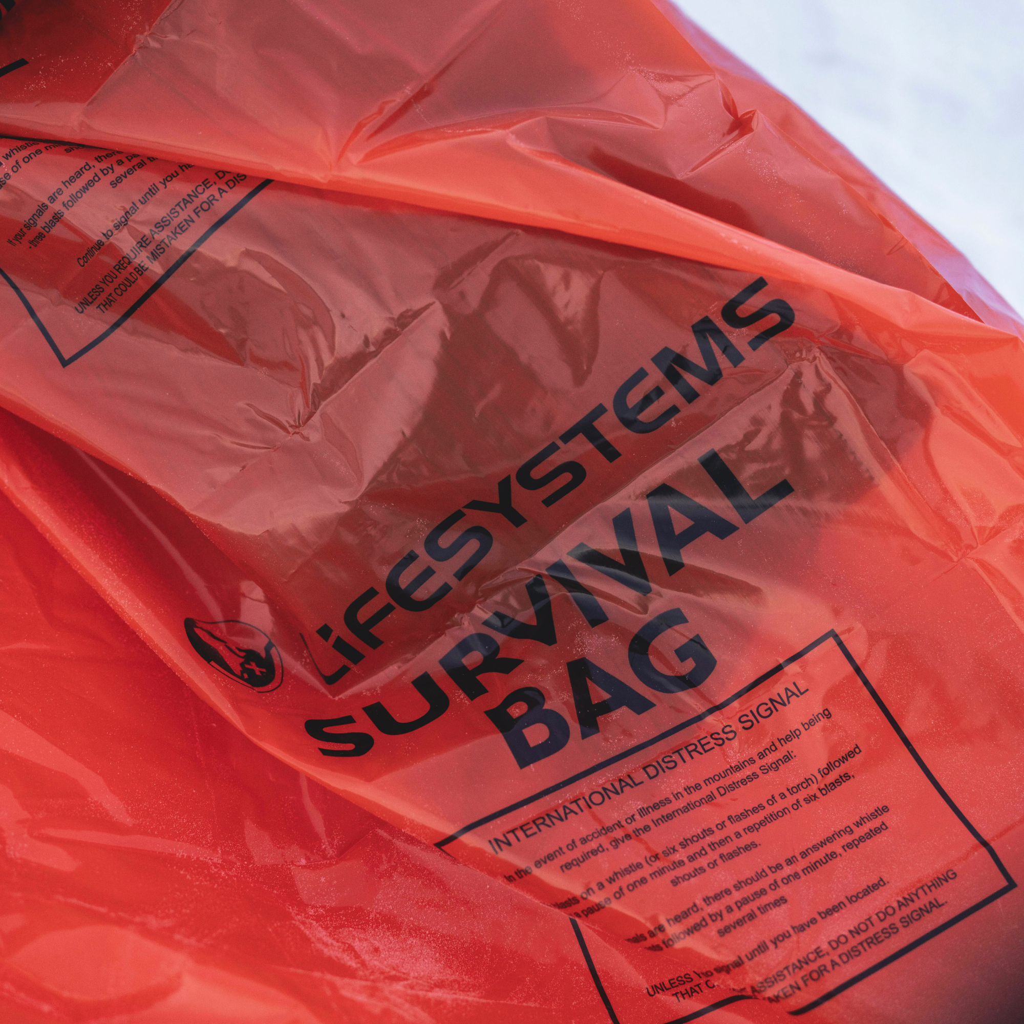 A close-up of a Lifesystem Emergency Survival Bag Orange 2090