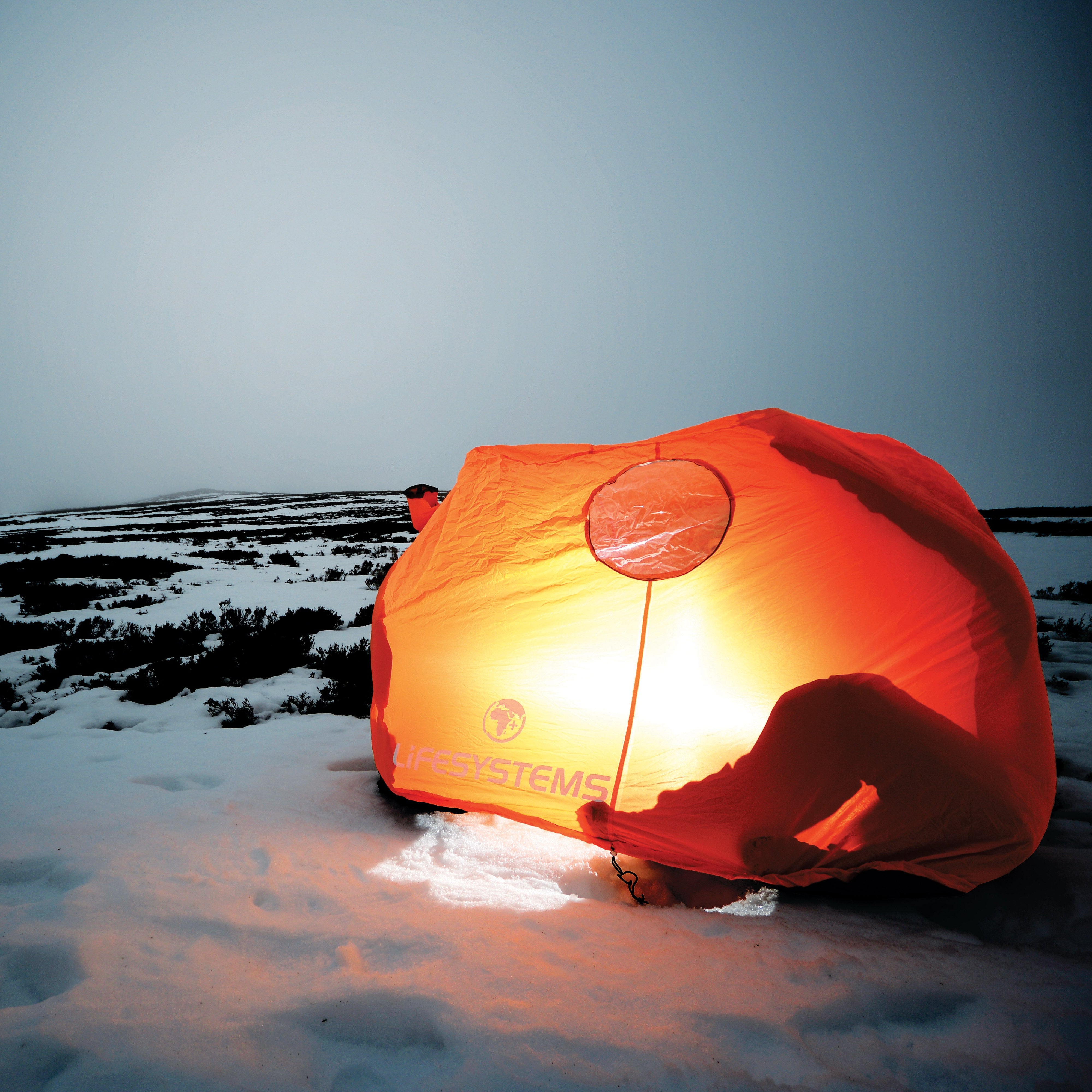 Lifesystems Survival Shelter 2 People Orange 42311 on a snowy landscape