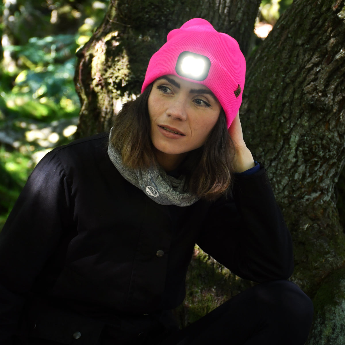 Person wearing a Six Peaks Unisex LED Lighted Beanie Hat Pink SIH0004 in a forest setting
