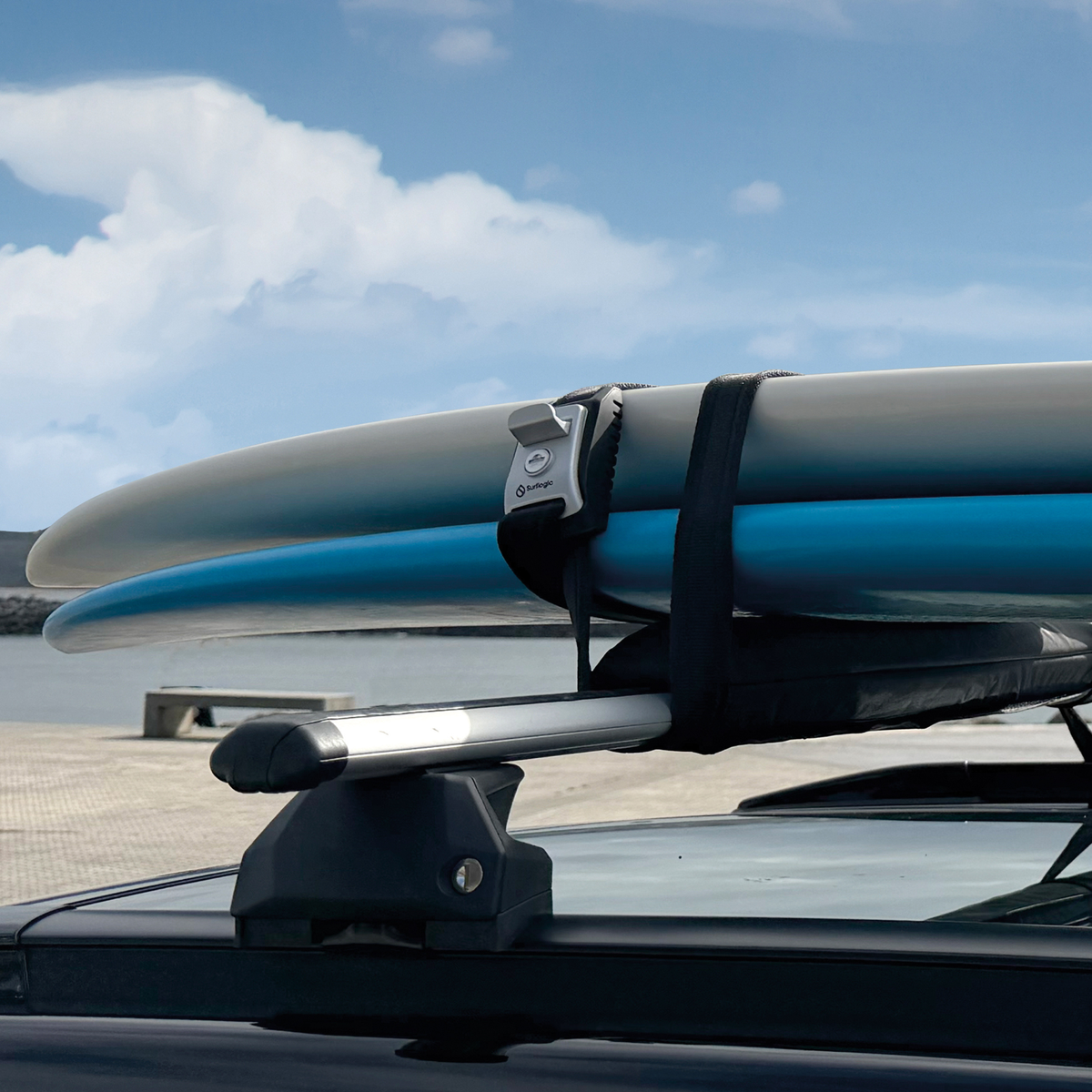 Surflogic Lockable Tie-Down Straps securing 2 surfboards to the roof rack of a car