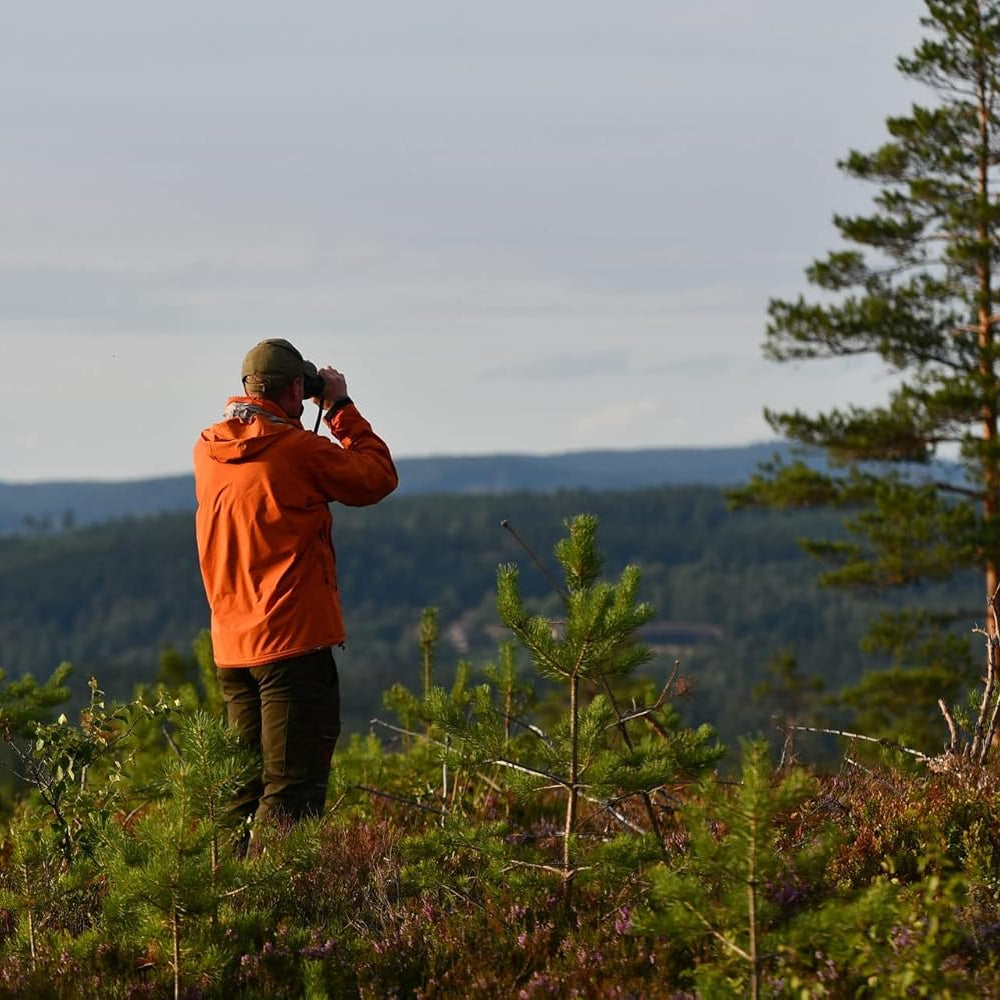 Man using Tasco Essentials Compact Binoculars Black 10 x 25 TA168125 looking over the hills