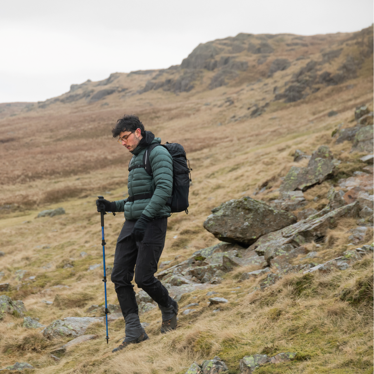 Person hiking on a rocky hillside with backpack and Trekmates Trekker Compact Single Pole Cobalt TM-008702