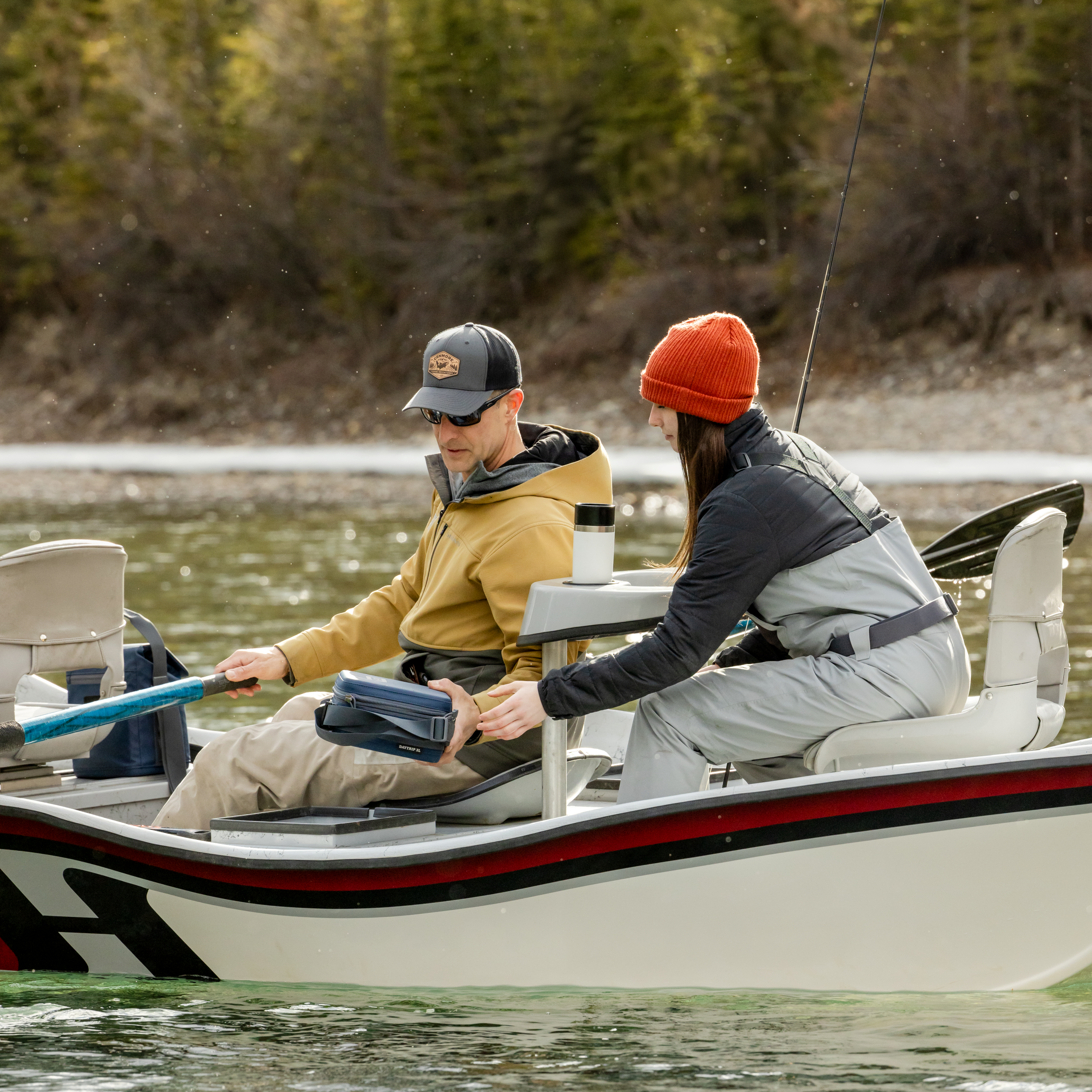 Young girl and her dad fishing from a boat on a lake. White Yeti travel bottle with commuter lid sitting in a cup holder