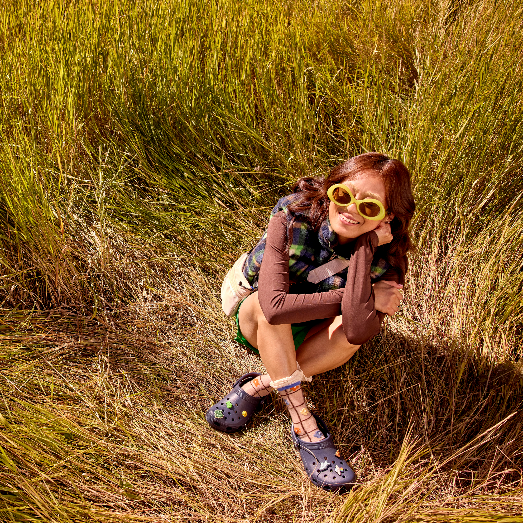 Woman wearing 10001 Crocs Classic Unisex Clogs Navy 410 sitting in the grass