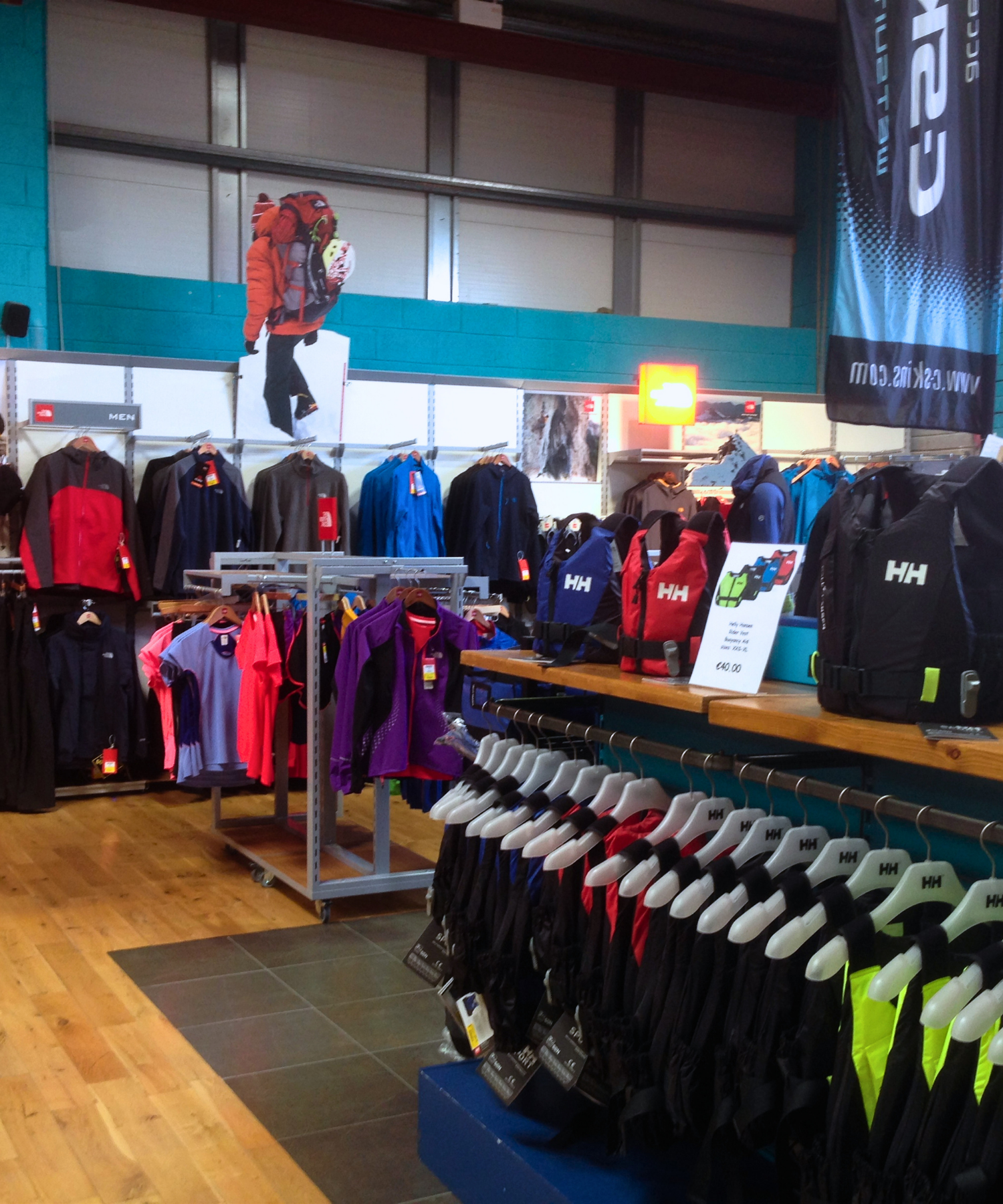 Store interior with clothing racks and promotional banners featuring Helly Hansen clothing and lifejackets, Columbia clothing in Landers Tralee