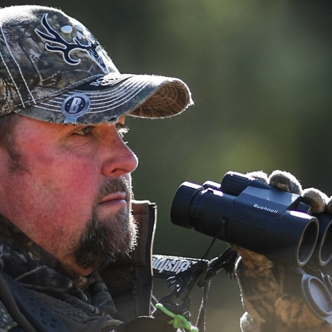 Man using Bushnell Prime Binoculars  wearing camo outside