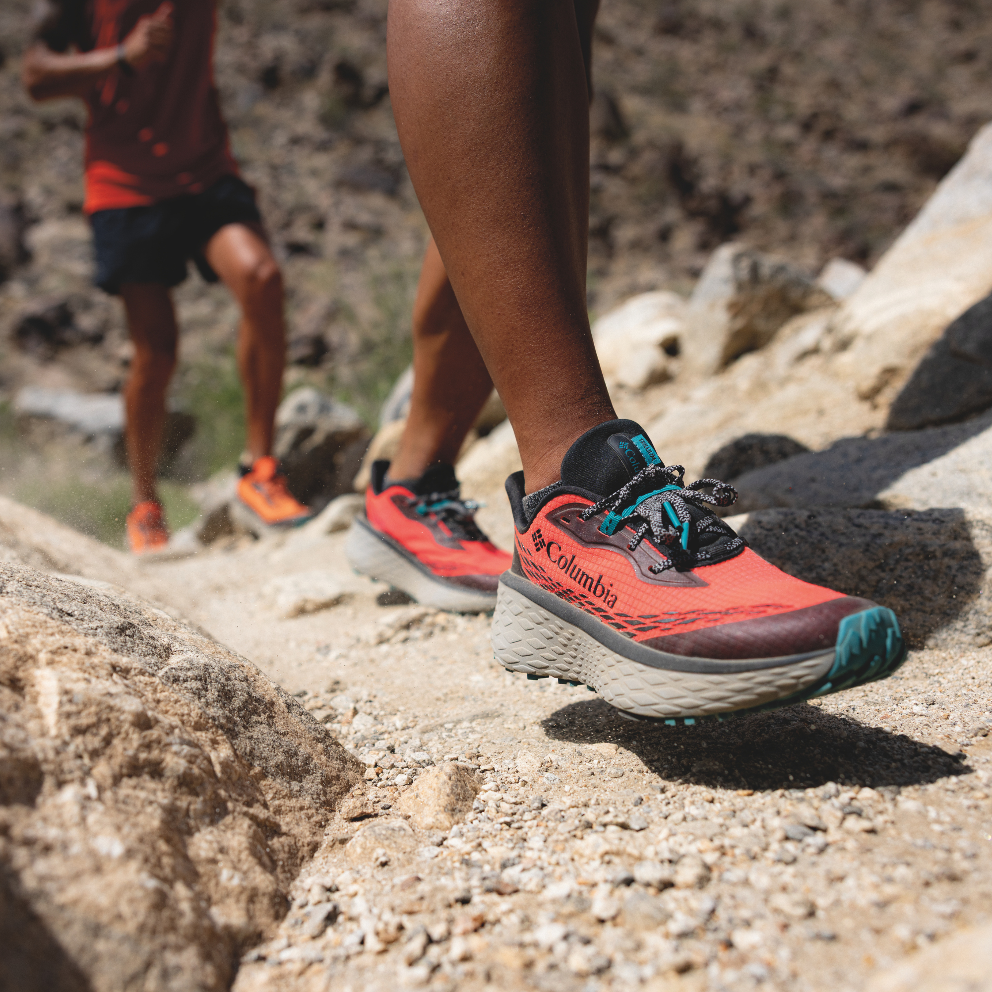 Woman trail running in Columbia Women's Konos Trillium ATR Trail Shoes Neon Sunrise Teal Chloride 648 2145291 on desert gravel surface