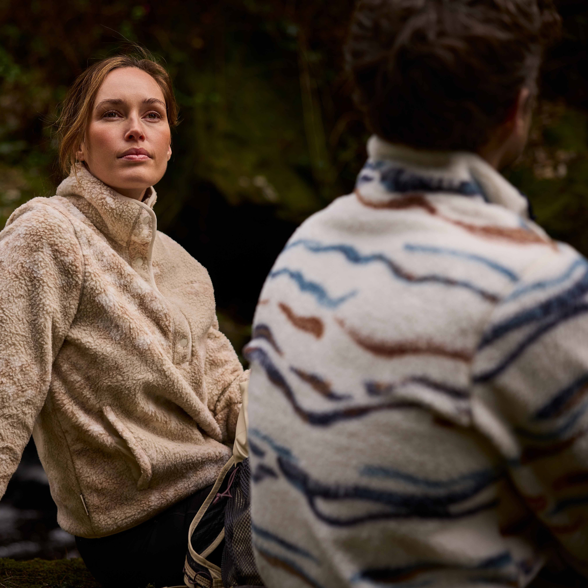 Man wearing Craghoppers Men's Rawthey National Trust Half Zip Fleece Top Ecru Winterstorm 1XJ CMA1425 shown from behind, facing away from the camera. A woman sitting beside him.
