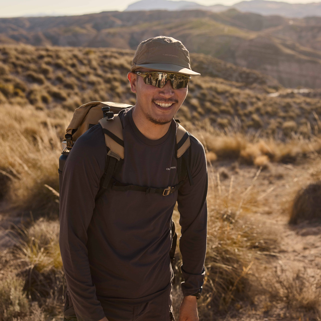 Man wearing Craghoppers Unisex Nosilife Desert III Sun Hat Pebble 695 CMC132 while hiking in the desert