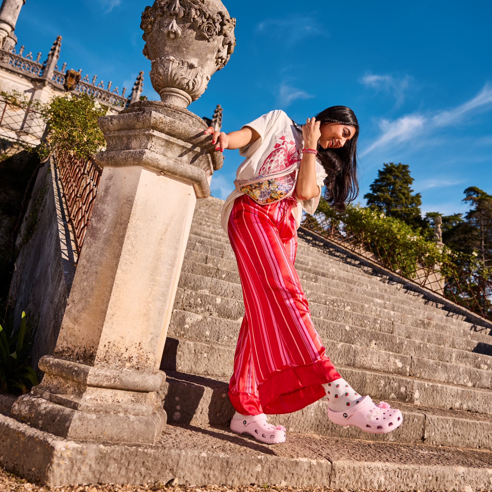 Woman wearing Crocs Unisex Classic Clogs Pink Milk 6ZW 10001 standing on stone steps