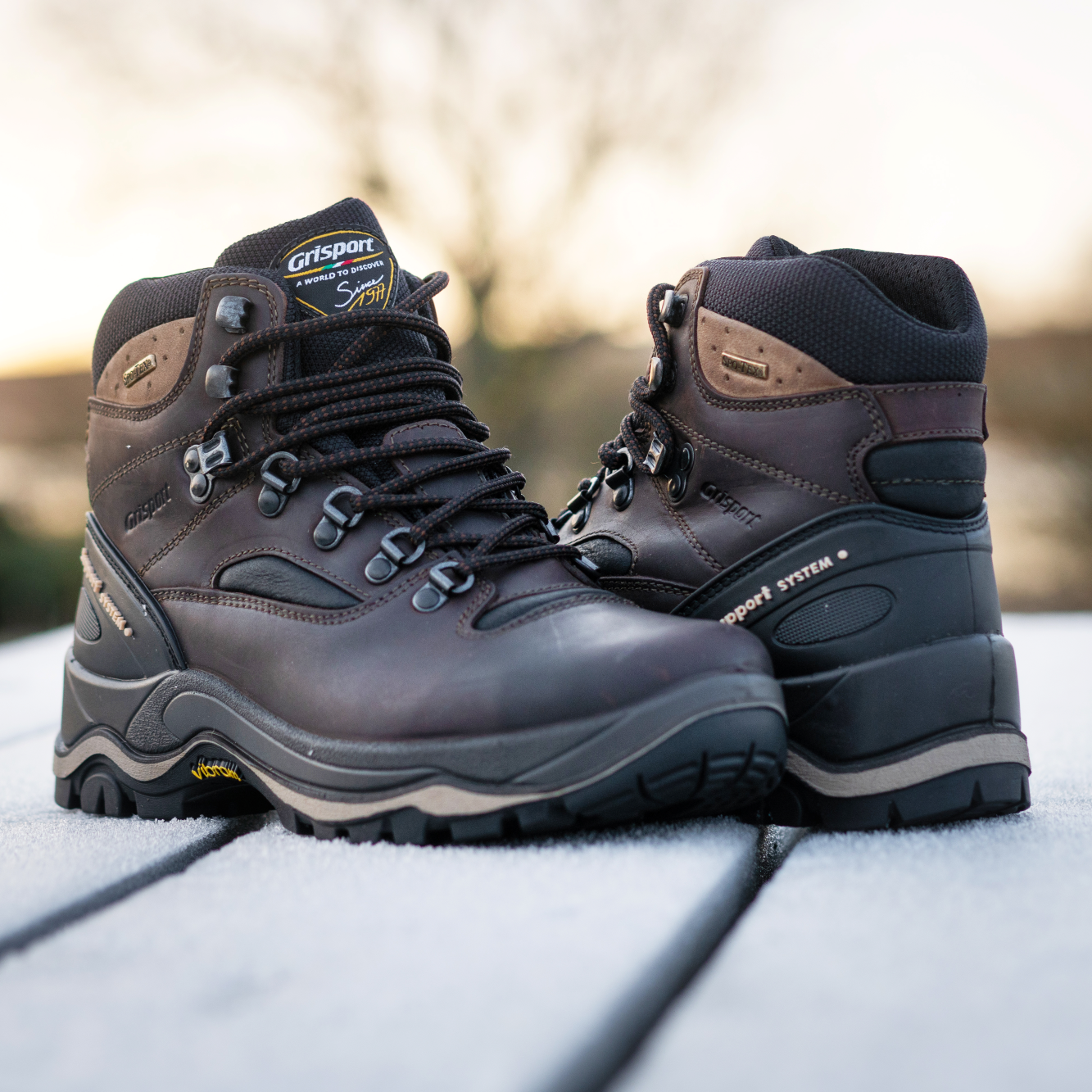 Grisport Men's Quatro Waterproof Hillwalking Boots Brown CMG614 sitting on a picnic table and yellow sky in the background