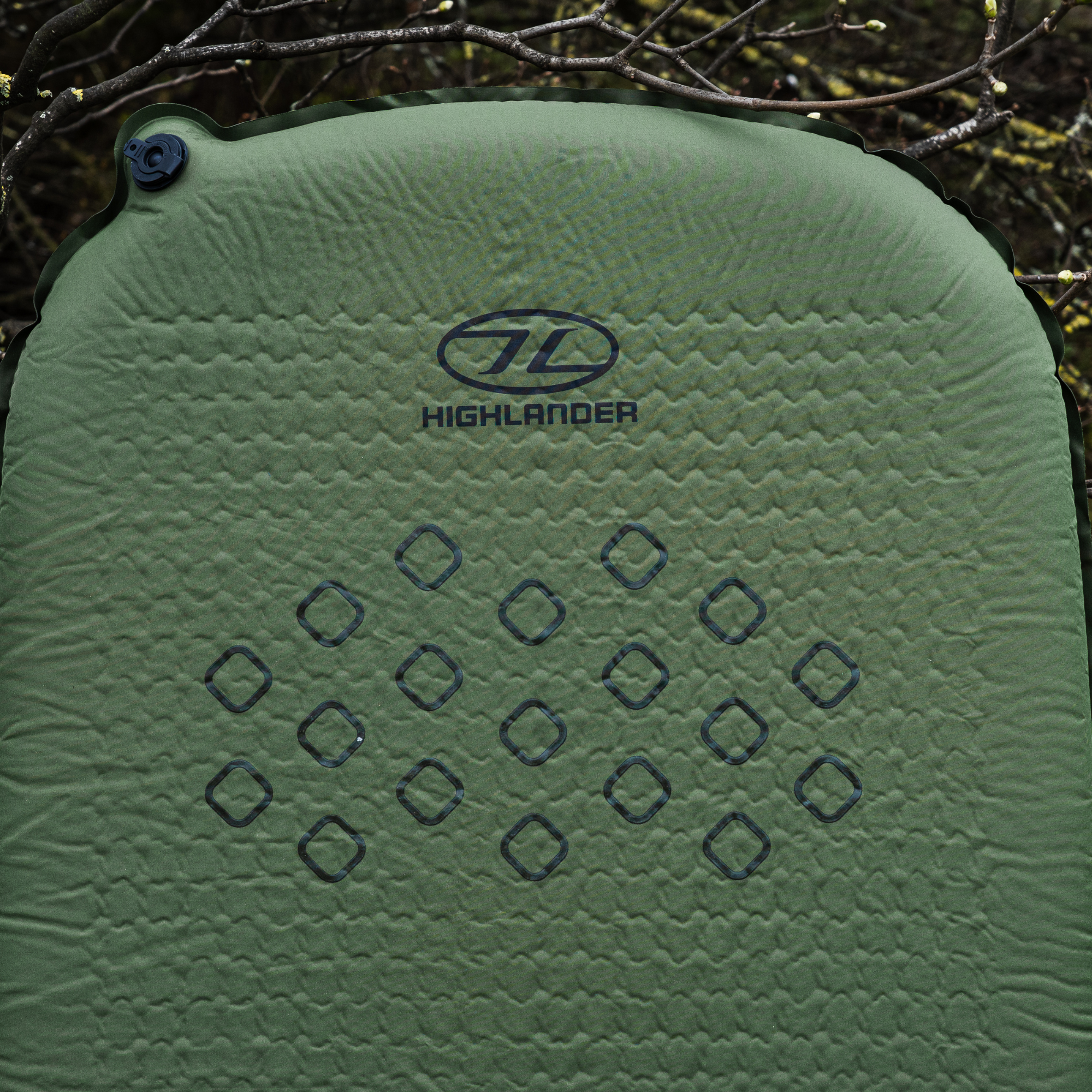 Highlander Self Inflating Kip Sleeping Mat 75mm Olive Green SM132-75 sitting on a forest floor