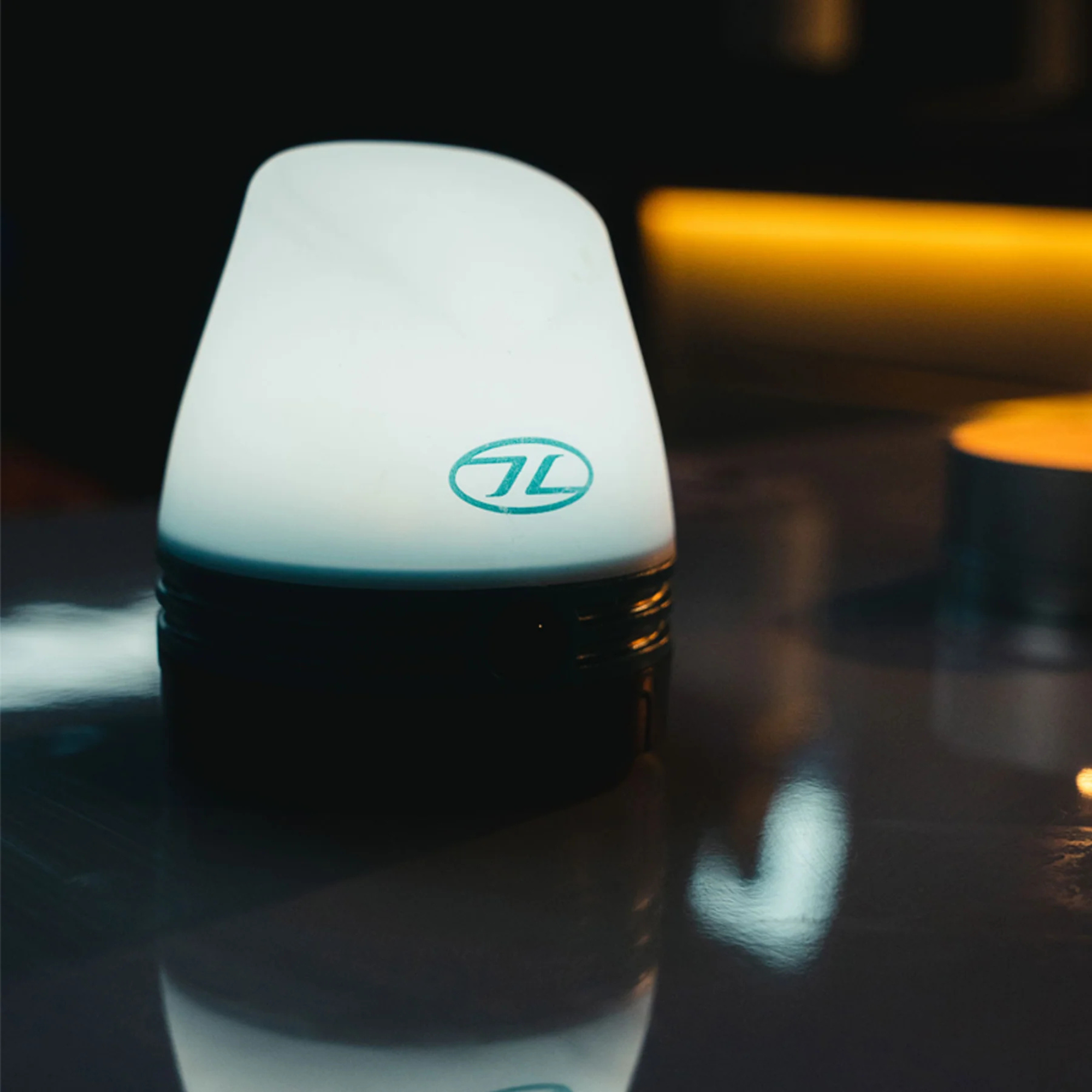 Highlander Wee Lantern Camping Light TOR196-TL lit on a table