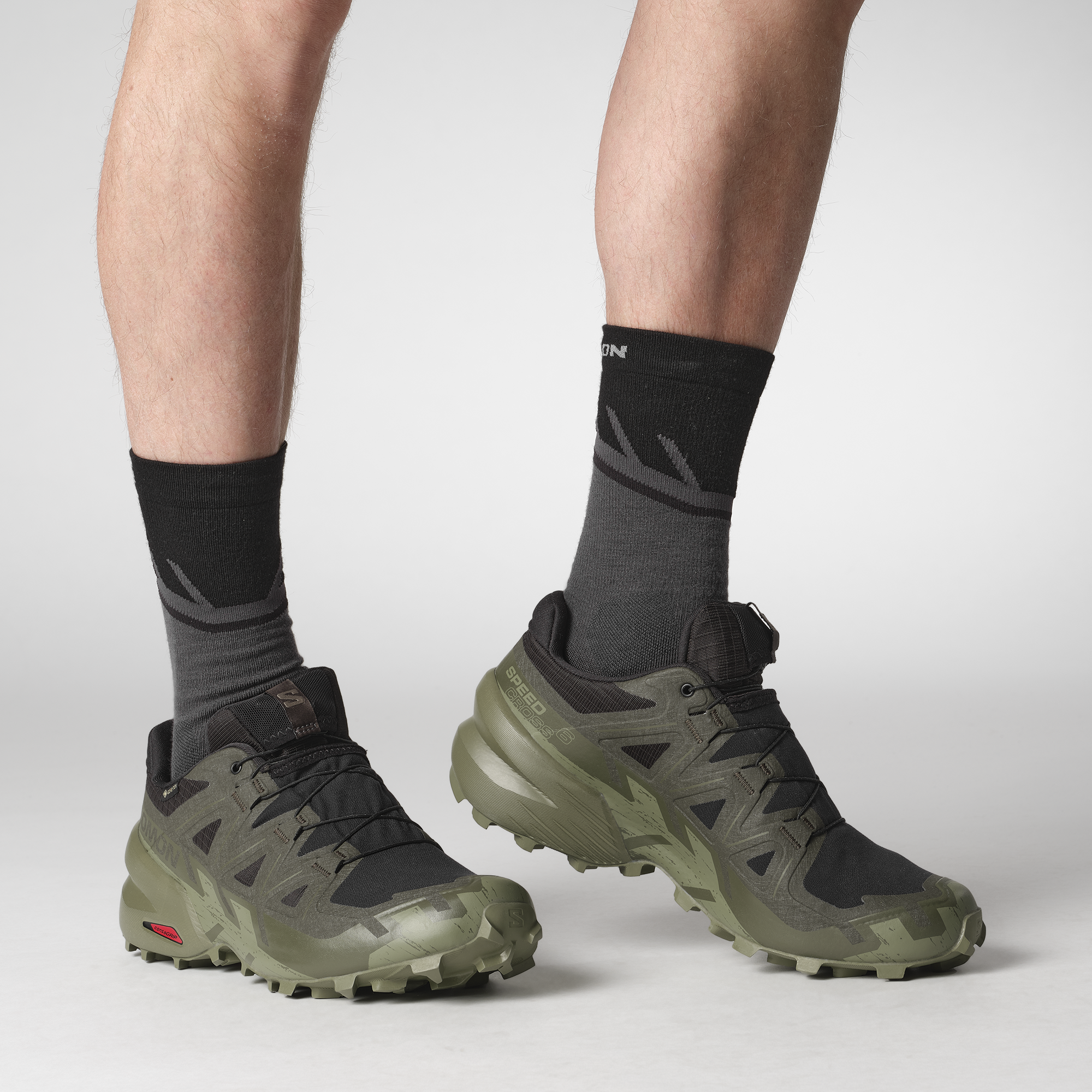 Man wearing Salomon Men's Speedcross 6 Gore-Tex Trail Running Shoes Black Peat Deep Lichen Green L47584100