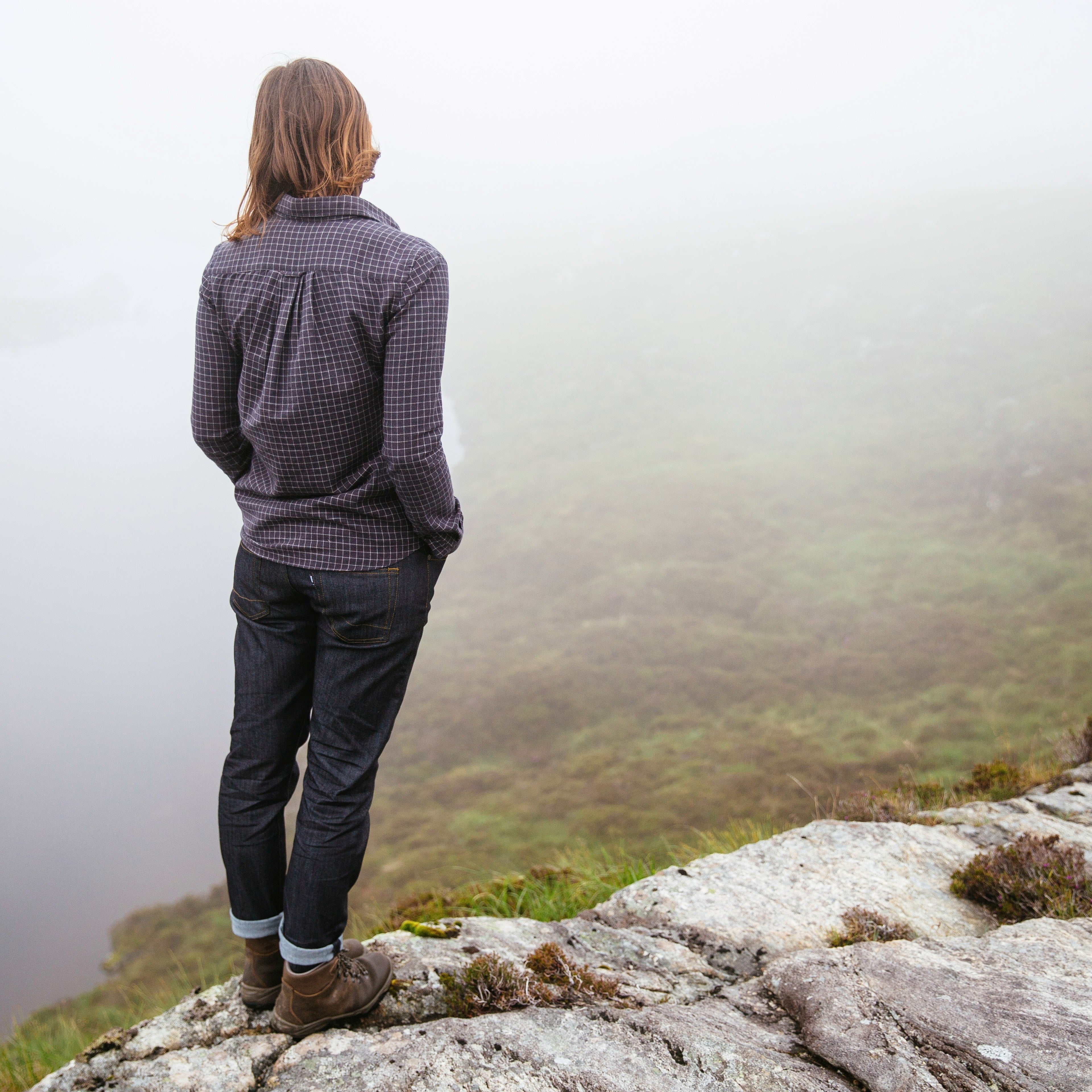 Woman wearing Scarpa Women's Terra Gore-Tex Hillwalking Boots Brown 30020-202N standing on a rocky outcrop looking into the mist