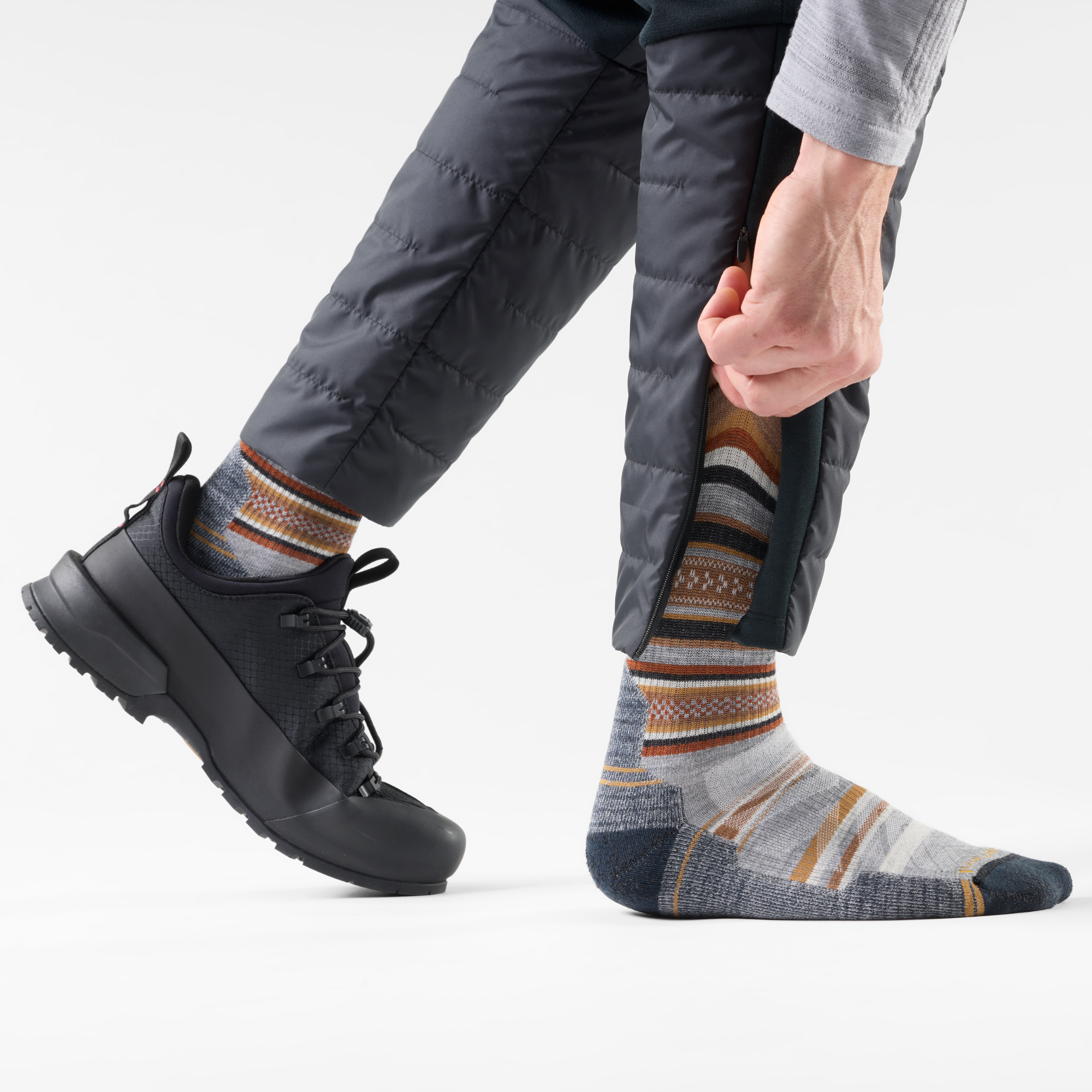Person wearing black shoes, black trousers and Smartwool Men's Print Panorama Hike Light Cushion Crew Length Merino Blend Socks Light Grey 039 SW002160 on a white background