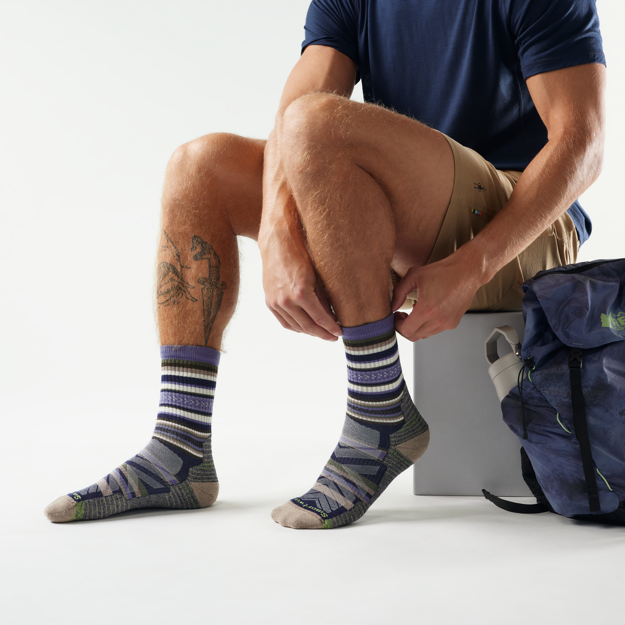 Person wearing Smartwool Men's Print Panorama Hike Light Cushion Crew Length Merino Blend Socks Nightfall Blue P43 SW002160 with a backpack on a white background