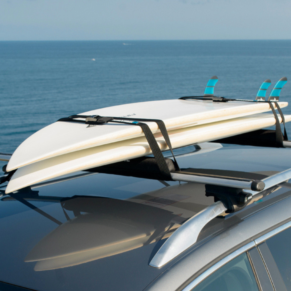 Surflogic Surfboard Tie Down Straps securing a surboard to the top of a car rack