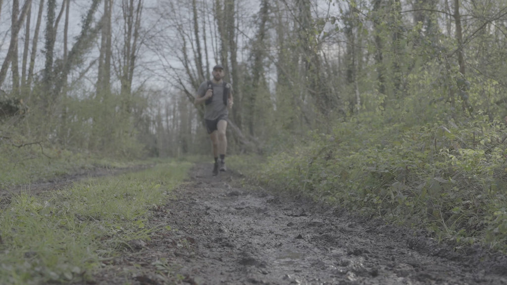 Video of man wearing Salomon Men's Speedcross 6 Trail Running Shoes Black Phantom L41737900 running through a muddy forest trail